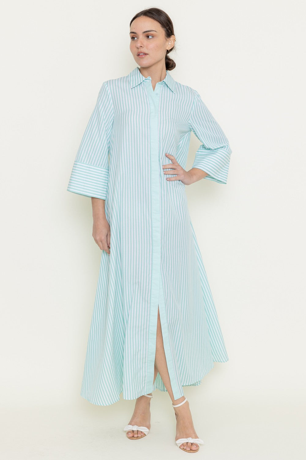 A collar neckline button down design with half sleeves with a striped pattern of green and white while has a loose relaxed fit.