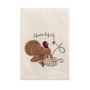 Decorative towel with a turkey and pumpkin design and the word 'thankful'.