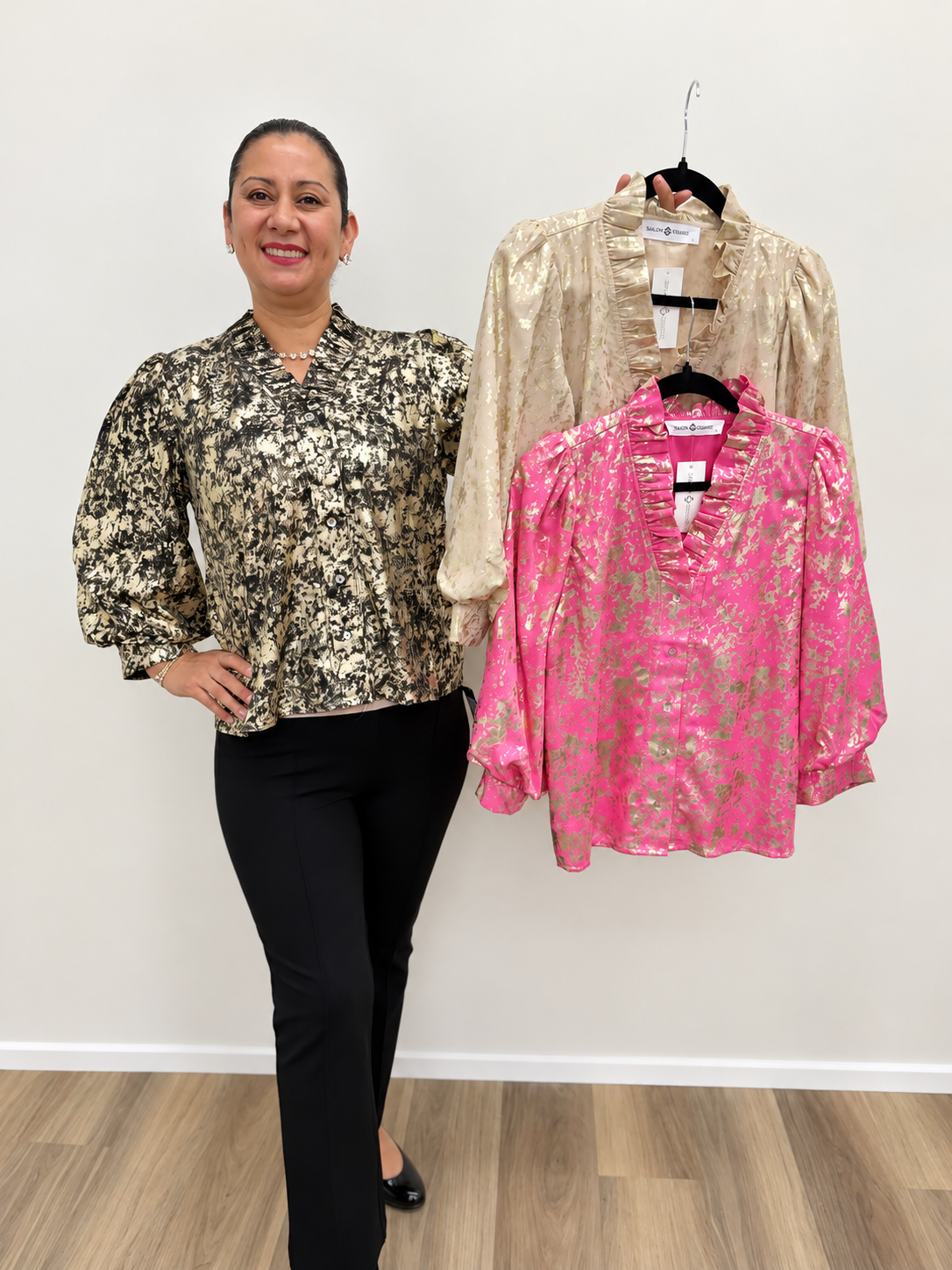 Women’s black and gold metallic print blouse featuring a button-front design, V-neckline, and long puff sleeves with cuffed wrists.