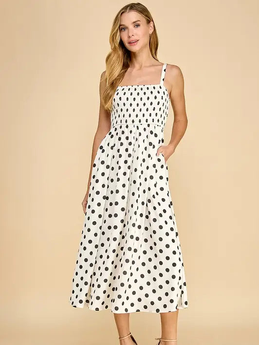 A black and white polka dot satin midi dress with pockets.
