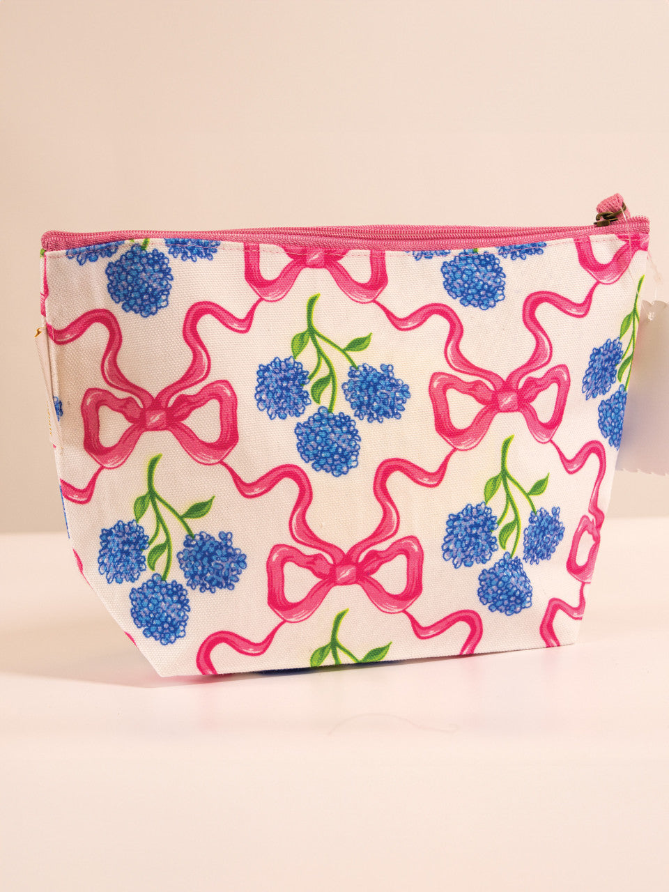 A cosmetic pouch with a bow and floral pattern.