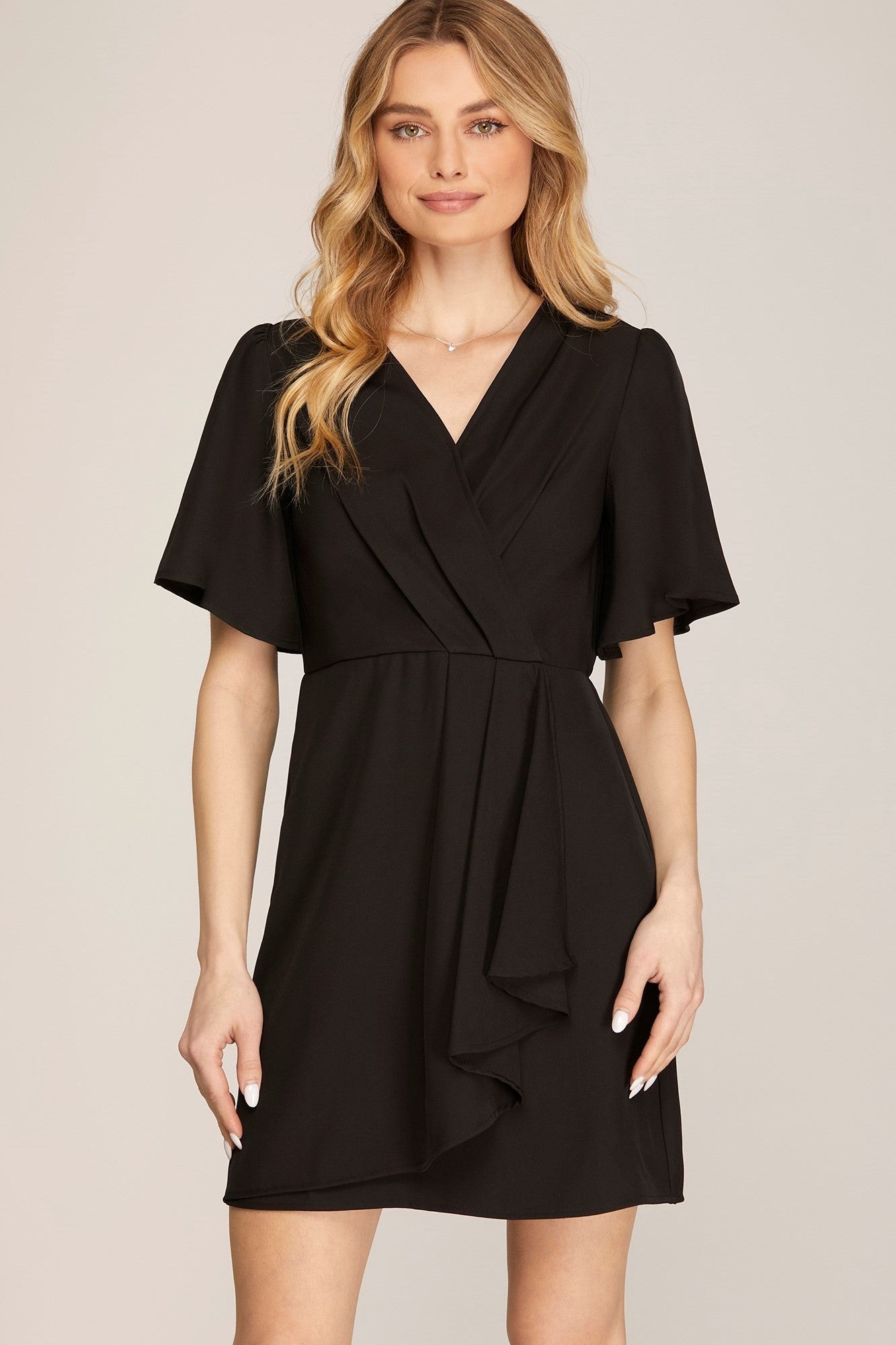 A black dress with a ruffled wrap design and short sleeves