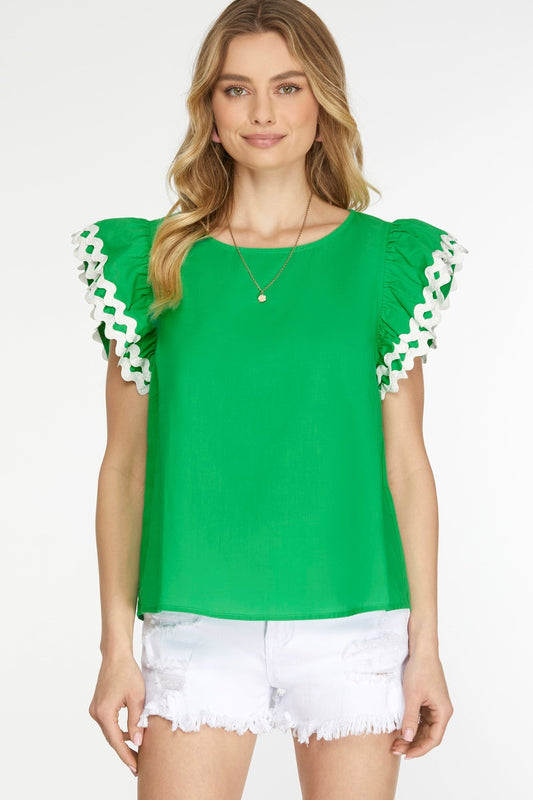 A green top with ruffle sleeves with white details at the end and a round neckline