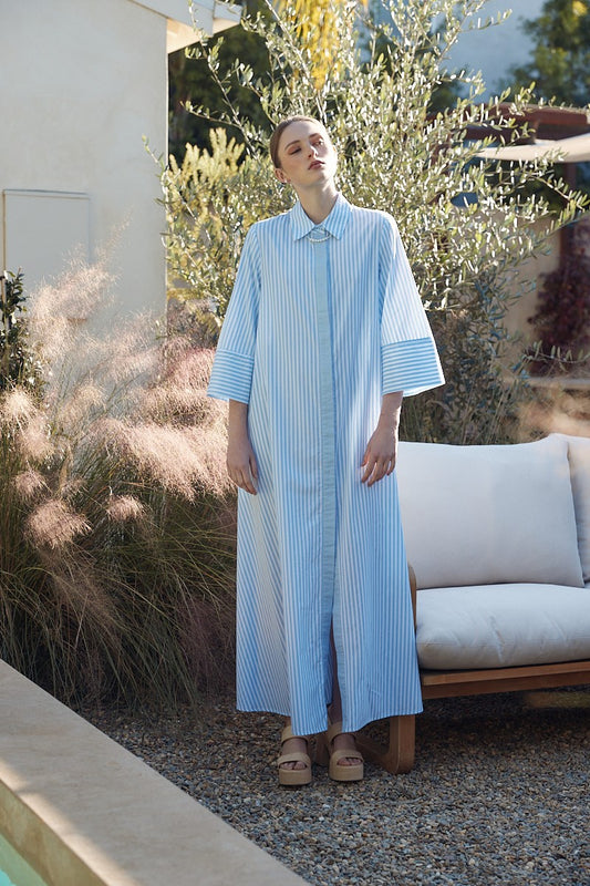 A collar neckline button down design with half sleeves with a striped pattern of blue and white while has a loose relaxed fit.