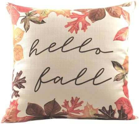 A cream pillow with a border of leaves and the center has the words "hello fall" in green cursive writing. 