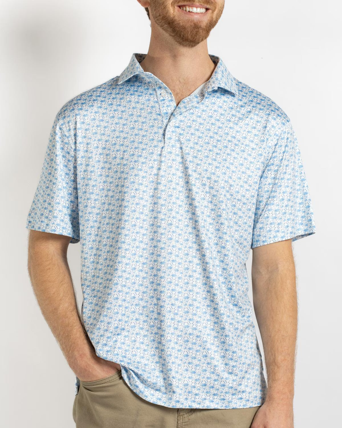 Men’s short-sleeve polo shirt in light blue and white, featuring an all-over small floral or botanical pattern, a classic collar, and a three-button placket.