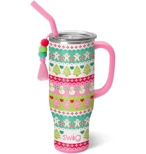 A Swig winter 30oz tumbler with a lid and straw and a decorative tassel hanging from the side. The tumbler has multiple horizontal bands featuring different patterns and designs, including snowflakes, hearts, Christmas trees and snowmen. Each band is in a