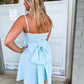 A short mint and white gingham print dress with a bow on the back. 