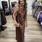 This is an elegant chocolate-brown satin maxi dress with a sleek, minimalist silhouette. It features a sleeveless design with a softly rounded bateau neckline, giving the bodice a clean and sophisticated finish.

The lustrous satin fabric drapes fluidly over the body in a relaxed, straight-to-slightly A-line shape, falling to a graceful floor-length hem. Its rich mocha/chocolate hue and subtle sheen give it a luxurious look without needing elaborate detailing. The understated design makes it especially vers