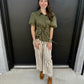 This is a chic olive-green utility-inspired blouse with feminine puff sleeves and a flattering cinched waist.

Color: Rich olive/army green, giving it an earthy, sophisticated feel.
Collar: Classic pointed shirt collar for a polished, tailored touch.
Front: Button-front closure with a clean, streamlined placket.
Sleeves: Statement short puff sleeves, gathered at the shoulders and finished with elasticized cuffs for added volume.
Waist: The standout detail is the drawstring waist with gold-tone grommets, all