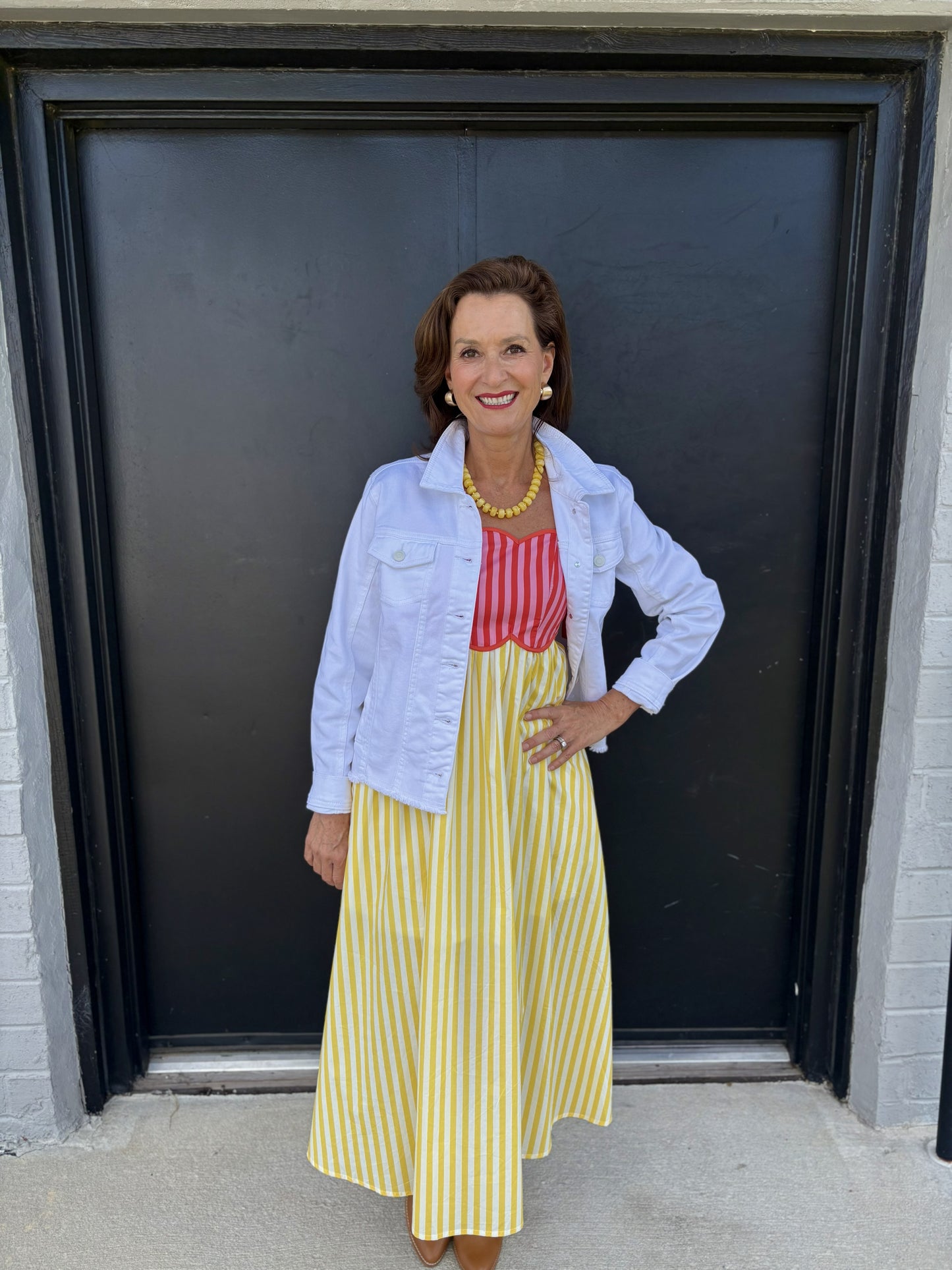 This classic white denim jacket is a versatile layering piece with a clean, polished look:

Color: Crisp white
Style: Traditional denim jacket with a structured, slightly fitted silhouette
Collar: Fold-over pointed collar
Front: Button-front closure with visible white buttons
Pockets: Two flap chest pockets with button closures
Sleeves: Long sleeves with buttoned cuffs
Length: Cropped at the waist/upper hip, making it easy to layer over dresses and tops
Fabric: Sturdy denim with a classic jacket structure