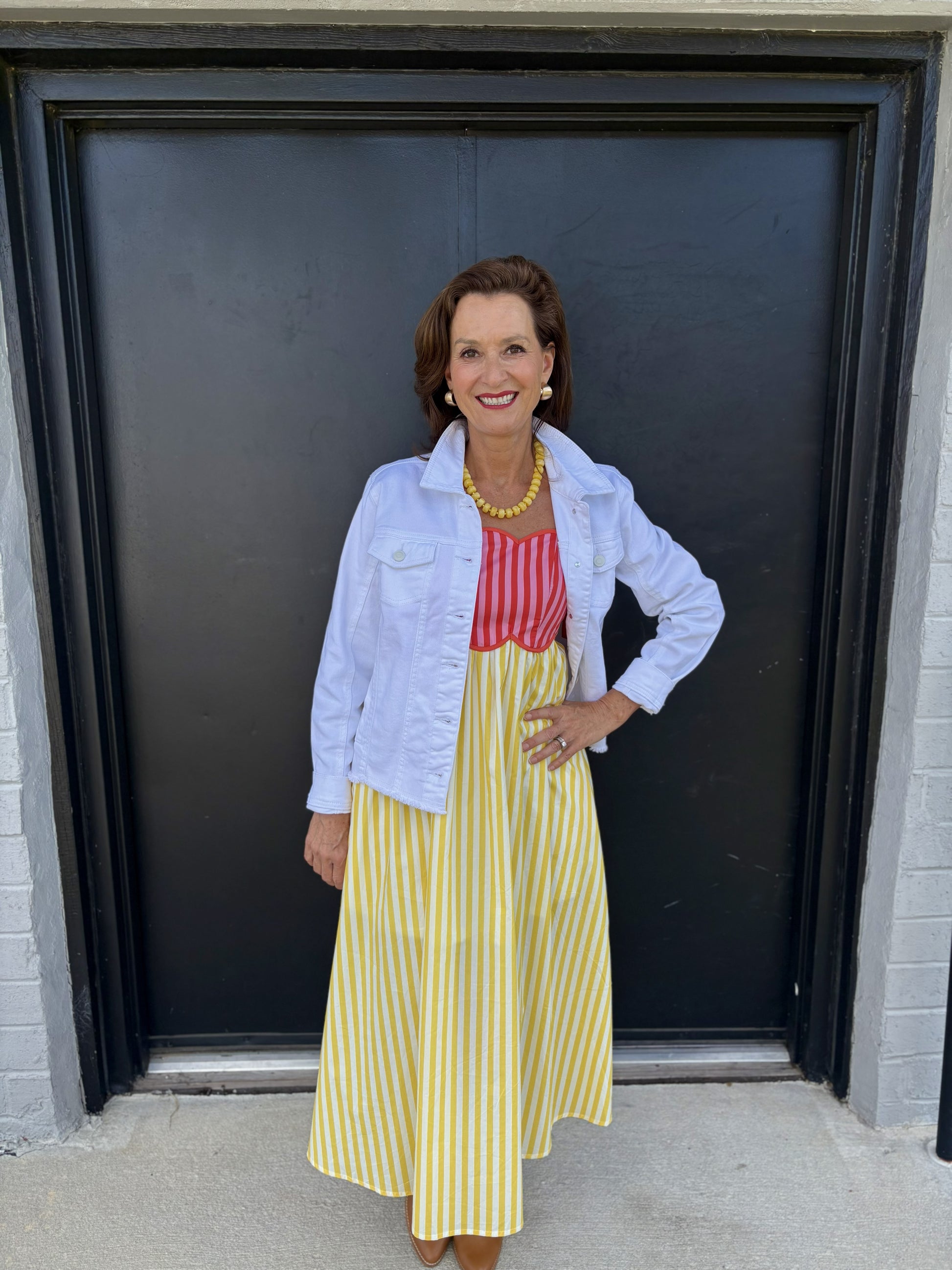 This classic white denim jacket is a versatile layering piece with a clean, polished look:

Color: Crisp white
Style: Traditional denim jacket with a structured, slightly fitted silhouette
Collar: Fold-over pointed collar
Front: Button-front closure with visible white buttons
Pockets: Two flap chest pockets with button closures
Sleeves: Long sleeves with buttoned cuffs
Length: Cropped at the waist/upper hip, making it easy to layer over dresses and tops
Fabric: Sturdy denim with a classic jacket structure