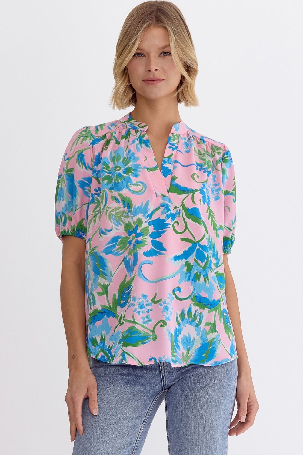 Printed v-neck short sleeve top featuring elastic at sleeves. Unlined. Woven. Non-sheer. Lightweight.
