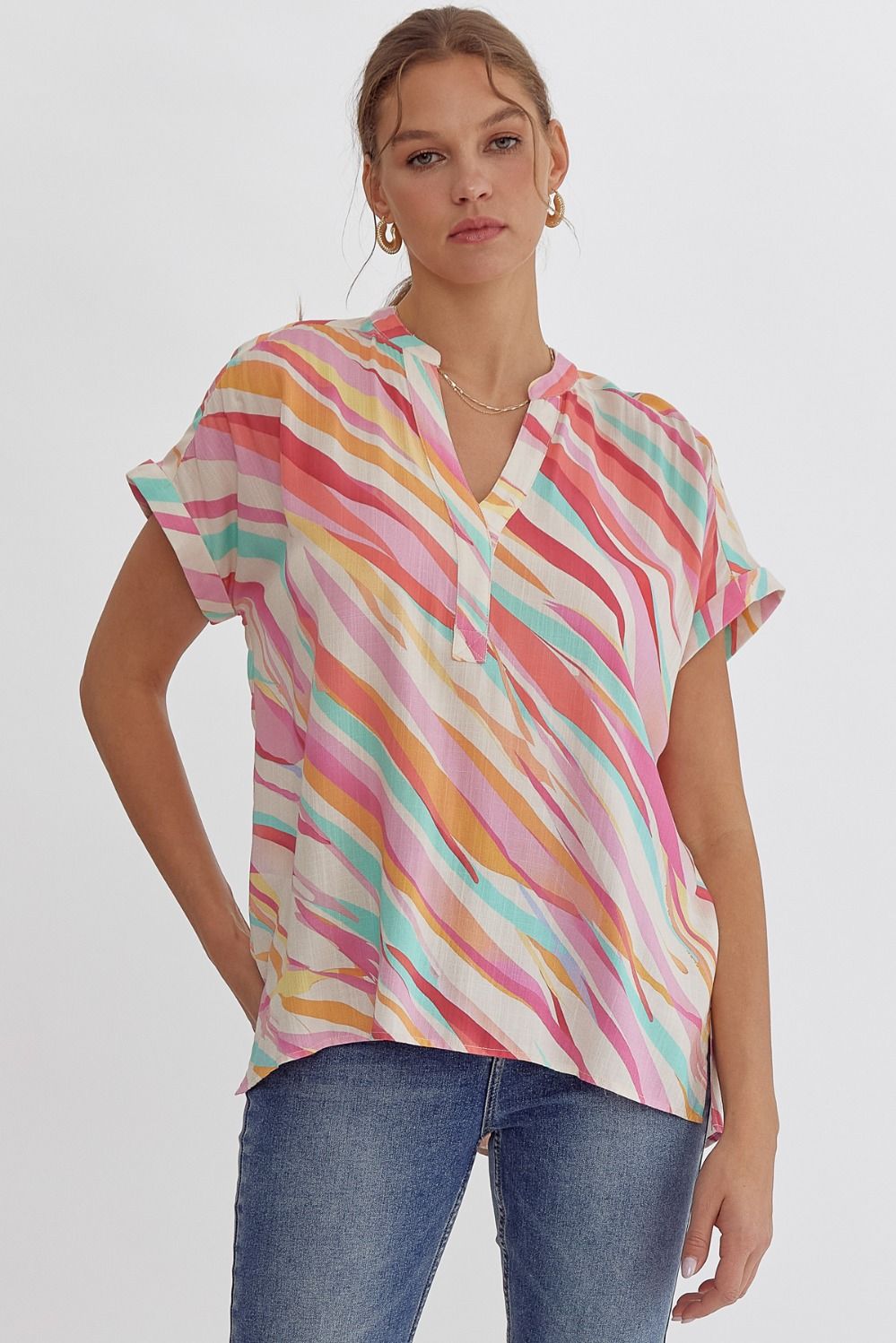Printed v-neck short sleeve top featuring permanent rolled cuff. Placket detail at neckline.