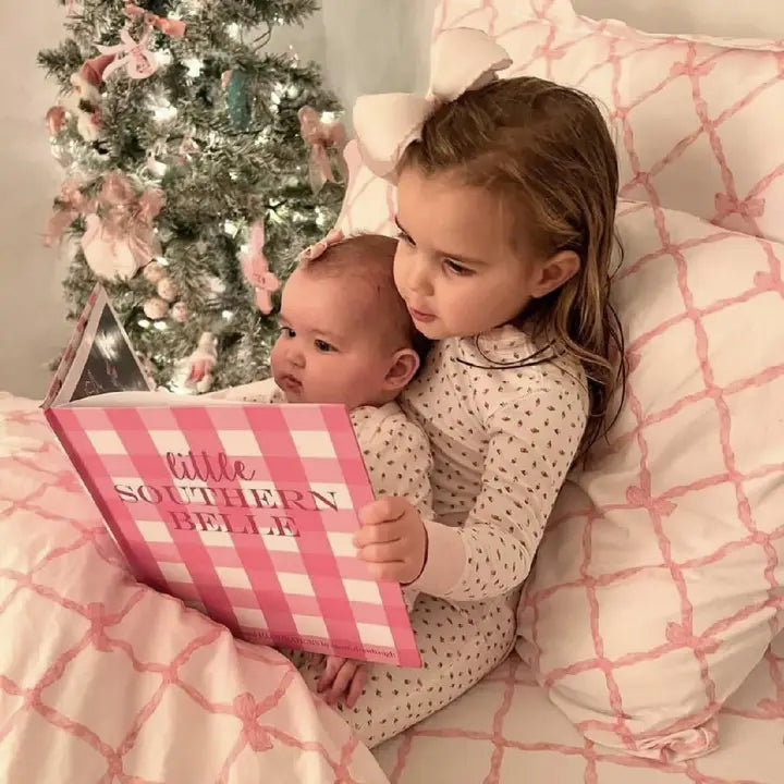 Little girl with baby sister reading the Little Southern Belle Book.