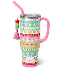 A Swig winter 40oz tumbler with a lid and straw and a decorative tassel hanging from the side. The tumbler has multiple horizontal bands featuring different patterns and designs, including snowflakes, hearts, Christmas trees and snowmen. Each band is in a