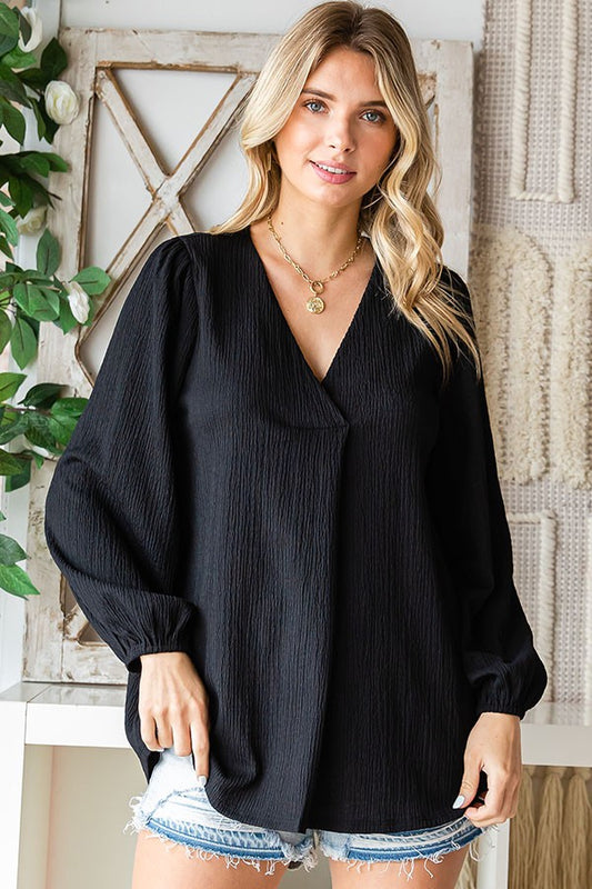 Plus Size Black top with v-neckline, elastic cuffed long sleeves, and a pleat detail