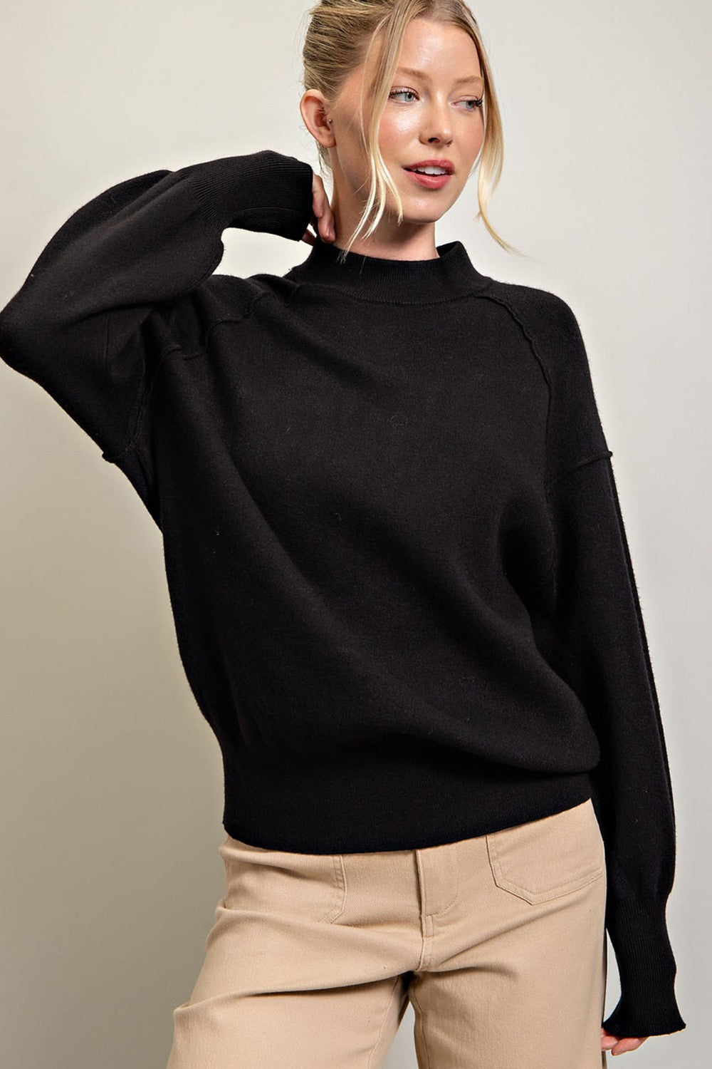 Black Solid long sleeve sweater featuring gauntlet cuffs to create a bubble sleeve effect, added seams for detail, a crew neckline, and a ribbed bottom band and neck.