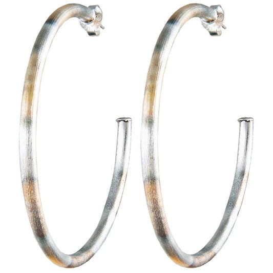 Silver tarnished hoop earrings with gold and dark metal hues.